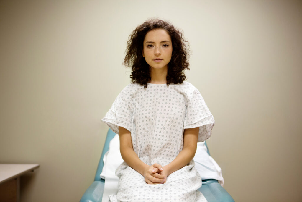 female patient in her early 20s staring straight at the camera